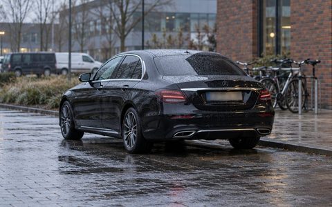 Zwarte Mercedes E-Klasse geparkeerd voor een kantoor